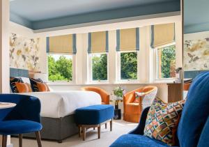 a bedroom with a bed and chairs and windows at Dylan in Dublin