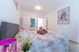 a teddy bear laying on a bed in a bedroom at Charming Home - Happy Rentals in Viganello