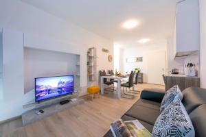 a living room with a couch and a flat screen tv at Charming Home - Happy Rentals in Viganello