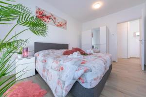 1 dormitorio con 1 cama grande en una habitación con planta en Charming Home - Happy Rentals, en Viganello
