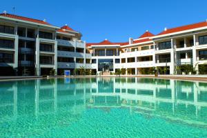 an empty swimming pool in front of some buildings at As Cascatas Golf Resort & Spa in Vilamoura