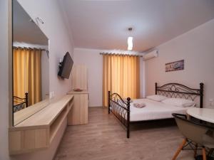 a bedroom with a bed and a sink and a tub at Vironas Hotel in Himare