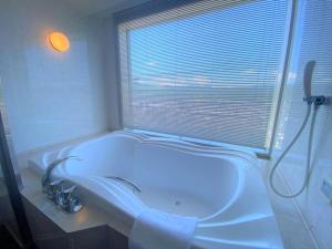 Sapporo Prince Hotel في سابورو: حمام مع حوض ومغسلة ونافذة