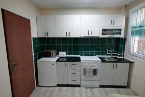 a kitchen with white appliances and green tiles at Rose's Apartment in Prilep +2 photos