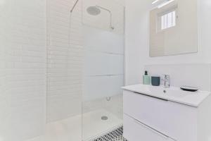 a white bathroom with a sink and a shower at Renovated Design Apartment In Montparnasse in Paris