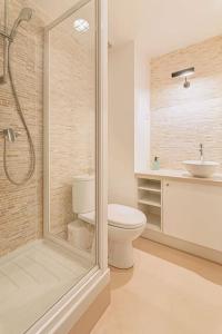 a bathroom with a shower and a toilet and a sink at Renovated Design Apartment In Montparnasse in Paris