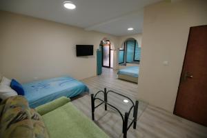 a room with two beds and a couch and a tv at Rose's Apartment in Prilep