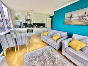 a living room with a couch and a table at Gorgeous Sea View Two Bed Apartment - Close to Beach with Free Parking in Bournemouth