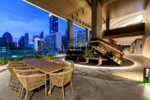 een tafel en stoelen op een balkon met uitzicht op de stad bij Axon Premier Suites Kuala Lumpur in Kuala Lumpur
