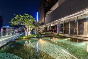 een zwembad voor een gebouw 's nachts bij Axon Premier Suites Kuala Lumpur in Kuala Lumpur