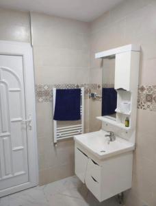 a white bathroom with a sink and a mirror at Résidence Le Figuier Marako, Tizi-Gheniff in Tizi Gheniff +74 photos