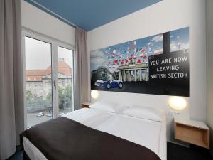 a bedroom with a bed and a large window at B&B Hotel Berlin-Charlottenburg in Berlin