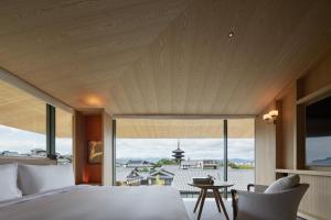 a bedroom with a large bed and a large window at Park Hyatt Kyoto in Kyoto