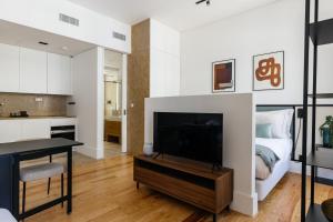 a living room with a television and a kitchen at The House on the Pink Street in Lisbon in Lisbon