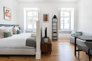 a white bedroom with a bed and a desk at The House on the Pink Street in Lisbon in Lisbon