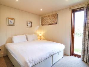 a bedroom with a large bed and a window at Barrowden in Cottesmore