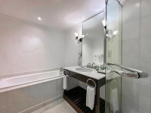 a white bathroom with a sink and a shower at Rebak Island Resort & Marina, Langkawi in Pantai Cenang