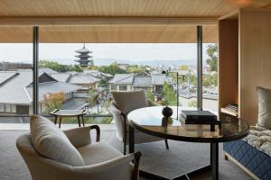 a living room with a table and chairs and a large window at Park Hyatt Kyoto in Kyoto