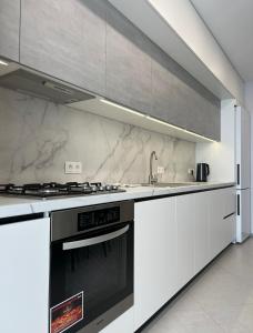 a kitchen with white cabinets and a stove top oven at VIP Апартаменти подобово in Lutsk