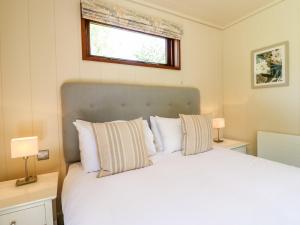 1 dormitorio con 1 cama con 2 lámparas y una ventana en Brooke, en Cottesmore