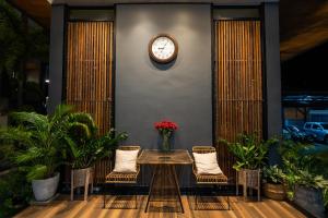 a table and chairs with a clock on a wall at Guuden Huahin Hotel in Hua Hin