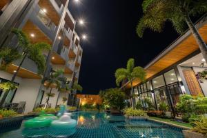 a swimming pool in front of a building at night at Guuden Huahin Hotel in Hua Hin