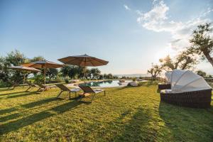 a yard with chairs and umbrellas and a pool at Privilegium Lazise in Lazise
