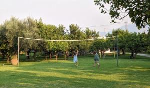 two children playing in a park with a volleyball net at Le Jardin de Temeni in Aígio
