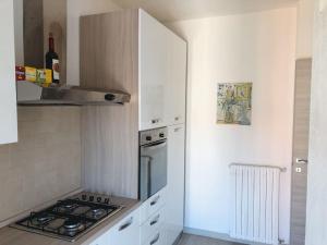 a kitchen with white cabinets and a stove top oven at Luis Apartment - Appartamento per single o coppia R7265 in Nuoro