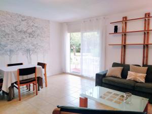 ein Wohnzimmer mit einem Sofa und einem Tisch in der Unterkunft Le Pouy, Jardin, Terrasse & Stationnement in Saint-Vincent-de-Paul
