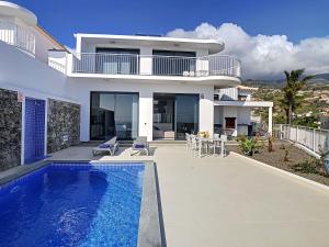 a house with a swimming pool in front of it at Casa dos Amores by LovelyStay in Calheta