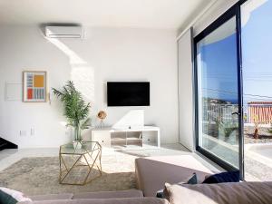 a living room with a couch and a tv at Casa dos Amores by LovelyStay in Calheta