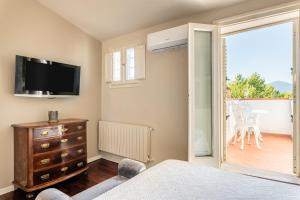 um quarto com uma cama, uma televisão e uma varanda em Terrazza Napoleone - Affitti Brevi Italia em Lucca