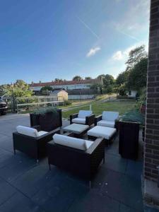 un gruppo di sedie e tavoli su un patio di Luxe woning ‘BARNS’ Castricum aan Zee + airco + parkeren a Castricum