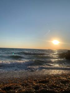 a beach with the sun setting over the ocean at Marseille Vieux Port in Marseille