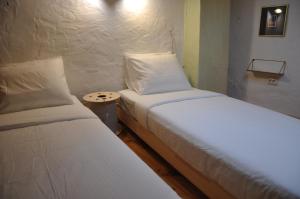 two twin beds in a small room with a table at Casinhas de S. Francisco T2 Azeitona by LovelyStay in Freixo de Espada à Cinta