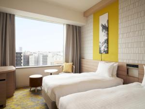 Sapporo Prince Hotel في سابورو: غرفة فندقية بسريرين ونافذة