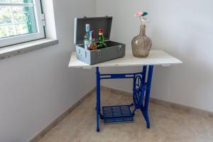 a table with a cooler and a vase on it at A Casa da Rapariga de Cabelo Azul in Manteigas