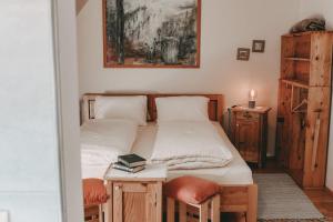 ein Schlafzimmer mit einem Bett und einem Tisch mit einem Buch in der Unterkunft Kultur Weingut Kästenburg in Ratsch an der Weinstraße