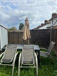 a table with two chairs and an umbrella on it at Spinners End in Watford