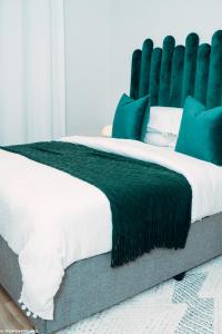a bedroom with a bed with a green headboard at Green with Envy-Luxury Apartment- No Loadshedding in Johannesburg