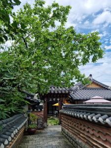a tree in front of a building with a brick wall at Gohyundang in Jeonju
