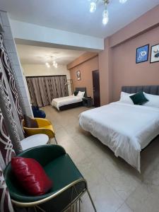 ein Hotelzimmer mit 2 Betten und einem Stuhl in der Unterkunft Haoyue Hotel in Jincheng