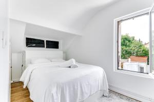 Habitación blanca con cama y ventana en La Bastille-Viroflay, en Viroflay