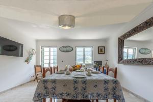 a dining room with a table and a mirror at A Casa da Rapariga de Cabelo Azul in Manteigas