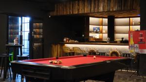 una mesa de billar roja en una habitación con bar en Kutabex Beachfront Hotel, en Kuta