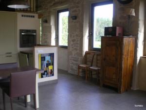 eine Küche mit einem Tisch, Stühlen und einer Theke in der Unterkunft Petit Gite De La Renaissante in Peyrins