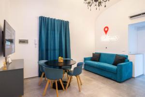 ein Wohnzimmer mit einem blauen Sofa und einem Tisch in der Unterkunft Casanica1 in Palermo