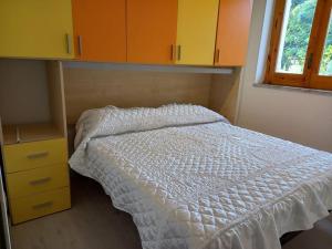 a bedroom with a white bed and a yellow cabinet at Villa Paradiso in Lamezia Terme