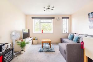 uma sala de estar com um sofá e uma mesa em Charming Entire 2-Bedroom House in Milton Keynes em Milton Keynes